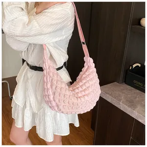 Detail of pink puff shoulder bag showing soft pleated texture and wide strap