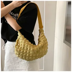 Detail of yellow puffy tote bag featuring soft pleated bubble fabric texture and strap