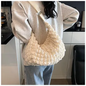 Close-up of beige popcorn texture fabric tote bag with wide canvas shoulder strap