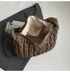 Interior detail of a brown quilted puff shoulder bag showing the lining and inner pocket