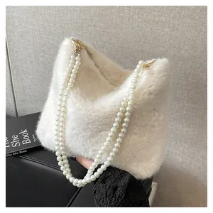 Détails du sac en fausse fourrure blanche avec poignée en perles et fermoirs métalliques