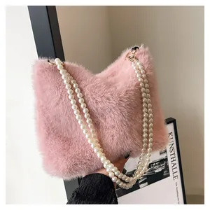 Vue détaillée du sac à main en peluche rose avec doubles lanières en perles élégantes