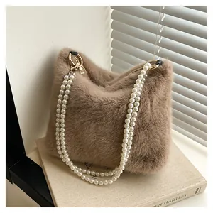 Gros plan sur le sac en fausse fourrure marron avec anses en perles et anneaux dorés