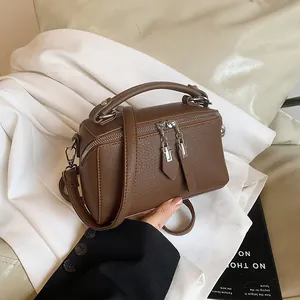 Classic dark brown pebble leather Boston bag with dual zippers and crossbody strap