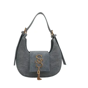 Gray suede crescent shoulder bag with golden logo and fringe tassel details