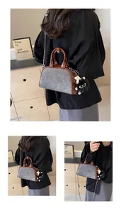 Detalle del bolso bandolera de patchwork de tweed y cuero con tachuelas y colgante