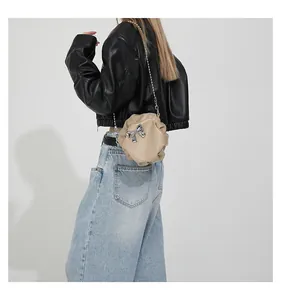 Détail du sac nuage plissé beige avec nœud argenté et bandoulière en chaîne fine