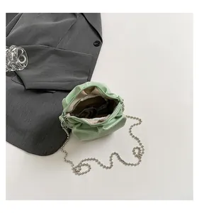 Détail du sac rond plissé vert menthe avec bandoulière chaîne et poche intérieure