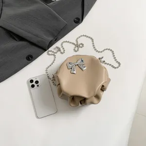 Petit sac rond plissé beige avec nœud argenté et bandoulière en chaîne perlée