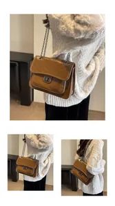 Détail du sac bandoulière marron avec surpiqûres en V et fermoir rotatif métallique