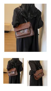 Détail du sac à chaîne marron brillant avec matelassage chevron et fermoir rotatif argenté
