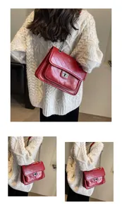 Détail du sac à chaîne en cuir bordeaux avec coutures en V et fermoir argenté chic