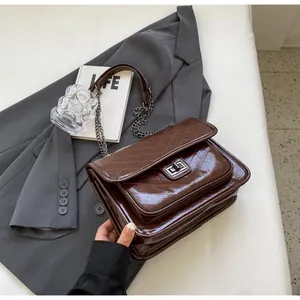 Détail du sac en cuir matelassé marron café avec chaîne en métal et fermoir rotatif
