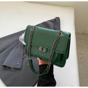 Détail du sac à chaîne matelassé en V vert foncé avec fermoir métallique brillant