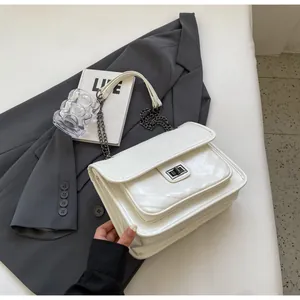 Détail du sac bandoulière blanc matelassé avec fermoir rotatif et chaîne