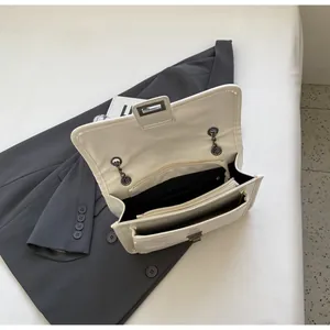 Structure interne du sac bandoulière crème avec compartiments multiples et fermeture