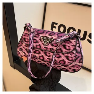 Vue macro de la texture léopard violette et de la plaque métallique sur le sac à main