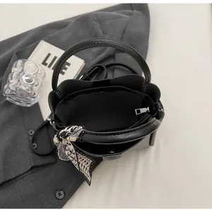 Vue détaillée de l'intérieur du sac seau en cuir noir avec trois compartiments et foulard