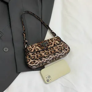 Sac baguette tendance à imprimé léopard avec logo métallique sur fond en tissu blanc