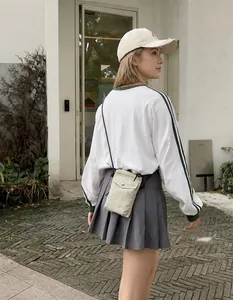 Primer plano de bolso pequeño para móvil en nylon beige sobre una modelo femenina