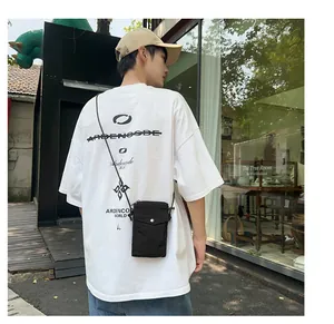 Detalle del bolso de nailon negro minimalista para móvil con botón de presión plata