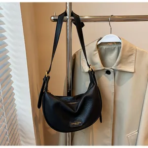 Elegante zwarte halfmaanvormige crossbodytas van generfd leer met gouden metalen gesp