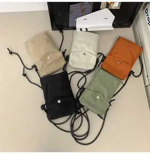 Vista plana de mini bolsos para móvil en nailon de colores con cordones ajustables