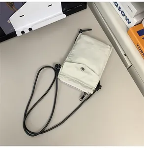 Detalle de bolso para móvil en nailon con bolsillo de botón presión y cremallera
