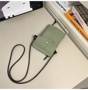 Detalle de bolsa de nylon verde claro para móvil con botón a presión plateado