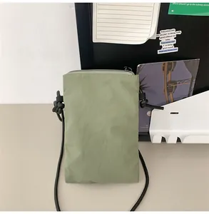 Primer plano del bolso de nylon verde oliva para móvil con tejido texturizado y correa fina