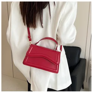 Model back view wearing red leather small square crossbody bag with wavy stitching detail