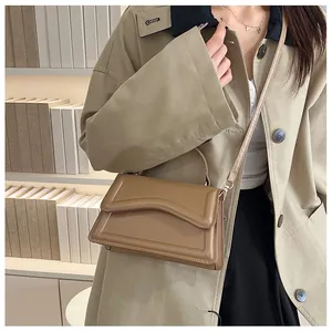 Detail of khaki square crossbody bag with wave texture flap and slim shoulder strap