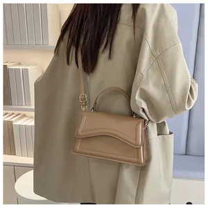 Detail of khaki square crossbody bag featuring wave stitching and adjustable strap