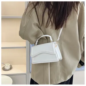 Detailed close-up of a white leather crossbody bag with wave texture worn by a model