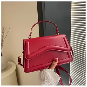 Detail of dark red matte leather bag with wave stitching and stylish top handle
