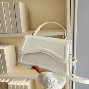 Chic beige crossbody bag with wavy flap detail and gold hardware for women
