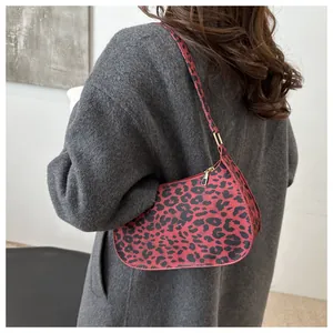 Dettaglio della borsa baguette leopardata rossa su cappotto grigio con cerniera dorata