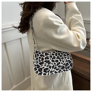 Dettaglio della borsa baguette con stampa leopardata bianca e nera indossata a spalla