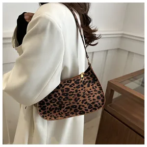 Dettaglio borsa baguette leopardata con cerniera in metallo dorato e tracolla sottile