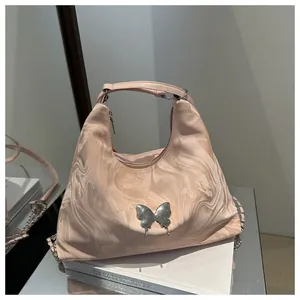 Detail of hobo bag featuring silver butterfly metal ornament and marble pattern texture