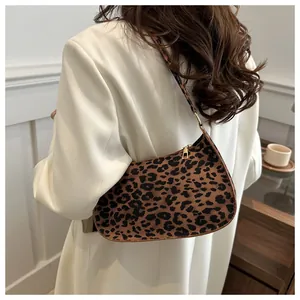 Dettaglio borsa baguette leopardata con cerniera dorata e tracolla in pelle chic
