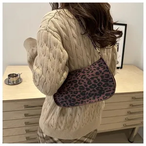 Dettaglio della borsa baguette leopardata su un mobile in legno in un interno accogliente