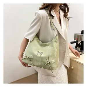 Dettaglio borsa hobo verde chiaro con fibbia a fiocco argento e trama stropicciata