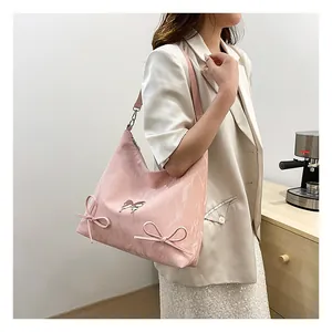 Dettaglio borsa tote in morbida pelle rosa con fiocchi eleganti e trama marmorizzata