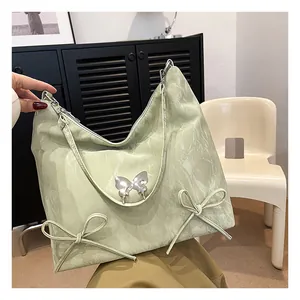 Dettaglio della borsa hobo verde menta con trama marmorea e fibbia a farfalla argentata