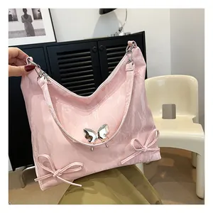 Dettaglio della borsa hobo rosa con farfalla metallica e fiocchi decorativi