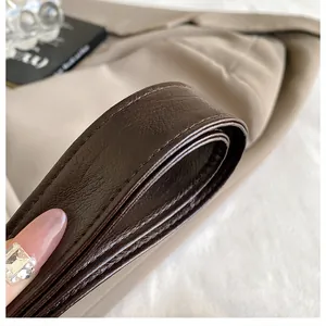 Detail of dark brown leather shoulder strap with neat stitching and smooth edge finish