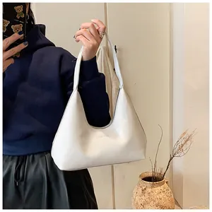 Detail of white leather hobo bag featuring embossed JIASHIQING logo and wide strap
