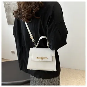 Détail de la texture cuir PU grainé blanc et de la boucle en métal doré du sac