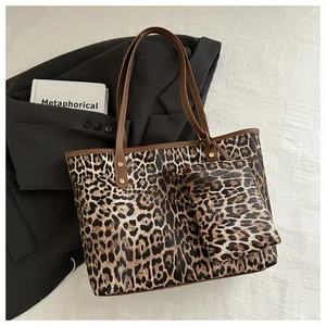 Detail of leopard print tote bag with matching inner pouch and gold rivet accents